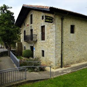 a stone building with a sign on the side of it at Hotel Doña Lola in Izarra