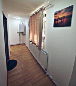 korytarzem pokoju z oknem i drewnianą podłogą w obiekcie Camere in regim hotelier w Braszowie