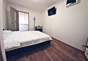 sypialnia z dużym białym łóżkiem i oknem w obiekcie Camere in regim hotelier w Braszowie