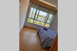 ein Schlafzimmer mit einem Bett und einem großen Fenster in der Unterkunft Piso en Portonovo con vistas a la playa in Sanxenxo