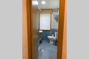 ein kleines Badezimmer mit Toilette und Fenster in der Unterkunft Piso en Portonovo con vistas a la playa in Sanxenxo