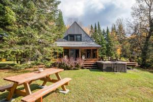 uma mesa de piquenique em frente a uma casa em The Beaver Lodge by Escapades Tremblant em Lac-Superieur