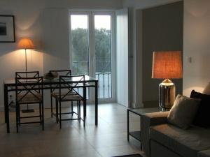Quintas de Obidos Apartments في فاو: غرفة معيشة مع طاولة وكراسي وأريكة