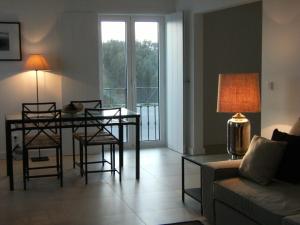 a living room with a table and chairs and a couch at Quintas de Obidos Apartments in Vau
