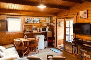 um quarto com uma cozinha e uma mesa num camarote em La cabane de Carol au coeur du bassin d'Arcachon em Le Teich