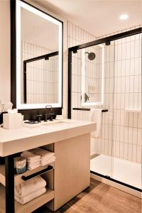 a bathroom with a sink, mirror and bath tub at Reverb by Hard Rock Atlanta Downtown in Atlanta