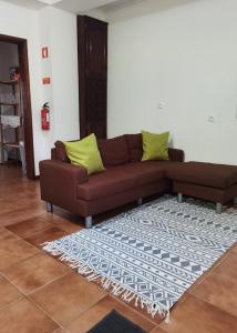 Sofá marrón en la sala de estar con alfombra en Casa da Sogra - Apartamento 1 en Faja Grande