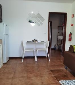 een witte tafel en stoelen in de woonkamer bij Casa da Sogra - Apartamento 1 in Faja Grande