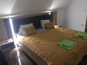 Bohemica Apartman 4 في Kouřim: غرفة نوم بسرير كبير عليها مناشف خضراء