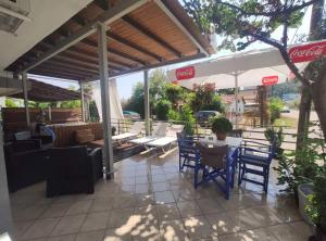 a patio with tables and chairs and an umbrella at Alexandros in Pýrgos