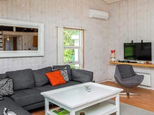 a living room with a couch and a tv at 10 person holiday home in V ggerl se in Bøtø By