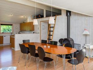 a dining room and kitchen with a wooden table and chairs at 10 person holiday home in V ggerl se in Marielyst