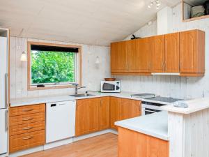 a kitchen with wooden cabinets and a window at 10 person holiday home in V ggerl se in Bøtø By