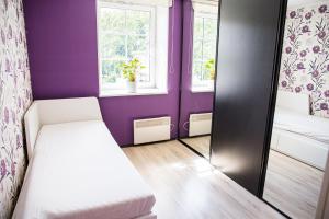 a small bedroom with purple walls and a mirror at 4 bedroom 166m2 apartment with sauna in the city 600m from the beach in a quiet family residence in Kuressaare