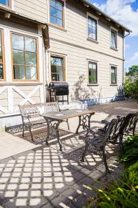 a picnic table and benches in front of a house at 4 bedroom 166m2 apartment with sauna in the city 600m from the beach in a quiet family residence in Kuressaare