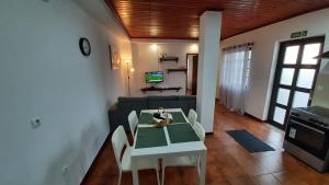een woonkamer met een tafel en een bank bij Casa da Sogra - Apartamento 2 in Faja Grande