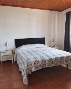 een slaapkamer met een bed met een blauwe en witte deken bij Casa da Sogra - Apartamento 3 in Faja Grande
