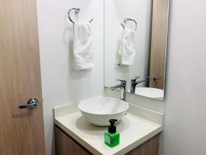 y baño con lavabo blanco y espejo. en Loft CHICÓ 103, parqueadero, Wifi 200 mgbs, Smart tv, en Bogotá