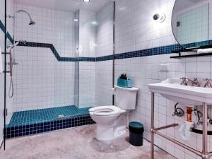 a bathroom with a shower and a toilet and a sink at Hotel Dryce in Fort Worth