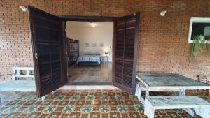 una puerta abierta a una habitación con cama en Hospedagem Econômica Flor de Maria, en Caraguatatuba