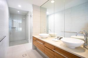 a bathroom with two sinks and a shower at 3 Bedroom Ultimate Luxury Waterfront in Cannonvale