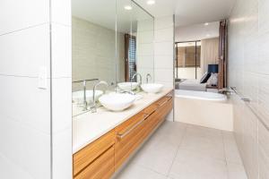 a bathroom with two sinks and a large mirror at 3 Bedroom Ultimate Luxury Waterfront in Cannonvale