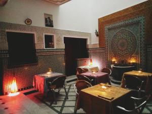 a restaurant with tables and chairs in a room at Hôtel Sid El Aidi Médina in Rabat