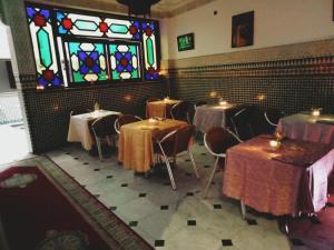a dining room with tables and a stained glass window at Hôtel Sid El Aidi Médina in Rabat