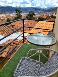 uma mesa e cadeira numa varanda com vista em wayra house san blas em Cusco