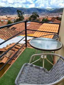 einen Tisch und einen Stuhl auf einem Balkon mit Aussicht in der Unterkunft wayra house san blas in Cusco