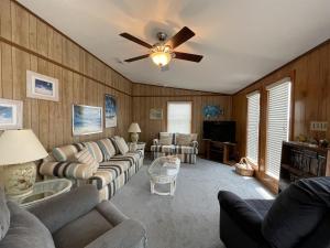 a living room with couches and a ceiling fan at SOUTHERN STAR cottage in Hatteras