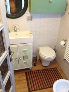 bagno con servizi igienici, lavandino e specchio di Casa Olivia a Firenze