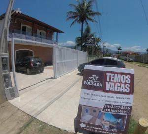 a sign in front of a garage with a car at Pousada Costa Mare in Bertioga