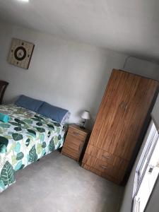 a bedroom with a bed and a wooden dresser at RoMa in Vista Flores