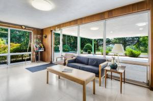 a living room with a blue couch and large windows at Alpine Motel in Abingdon