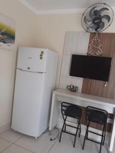 a kitchen with a refrigerator and a desk with two chairs at Lacqua diroma, BELEZA ROMANA I in Caldas Novas