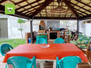 einen roten Tisch und Stühle in einer Außenküche in der Unterkunft ONJAU0100 - Lindo village perto da praia de Jauá in Camaçari