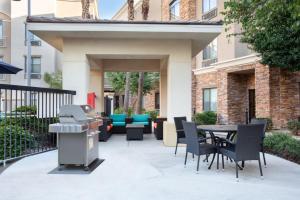un patio avec une table, des chaises et un grill dans l'établissement Staybridge Suites Phoenix Glendale Sports Dist, an IHG Hotel, à Glendale