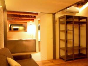 a living room with a kitchen and a room with a shelf at Homely Farmhouse in Pagnano Italy near Forest in Asolo