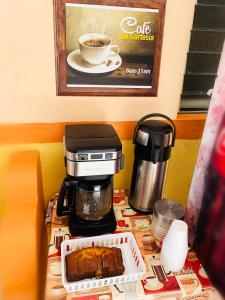 a coffee maker and a cake on a table at Hotel Isla Esmeralda in Cozumel