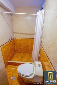 y baño pequeño con aseo y ducha. en Apartamentos Sami Cusco, en Cusco