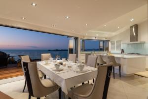 拉塞爾的住宿－Heaven NZ Luxury Accommodation- Qualmark 5 Star Accredited，一间带桌椅的用餐室和一间厨房