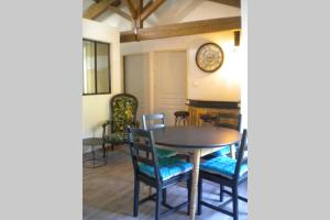 a dining room with a table and chairs and a clock at Appartement à FONTAINE DE VAUCLUSE in Fontaine-de-Vaucluse