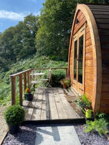 a wooden deck with a chair on a cabin at Hendre-Aur Glamping Pod in Machynlleth