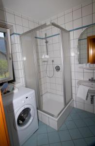 a bathroom with a shower and a washing machine at Apartmenthaus Berdnik in Kötschach