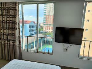 a bedroom with a large window with a flat screen tv at White Palace 2 in Thái Bình