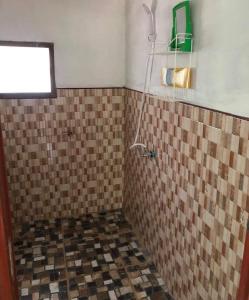ein Bad mit Fliesenboden und einem Fenster in der Unterkunft Garden Home, Chanthaburi in Ban Bo