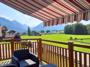 d'un balcon avec une chaise et une vue sur un champ. dans l'établissement Ferienwohnung Eisl, à Sankt Wolfgang im Salzkammergut