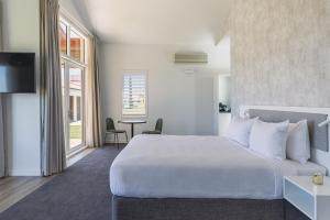 A bed or beds in a room at Rydges Formosa Auckland Golf Resort