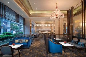 a restaurant with blue chairs and tables and a chandelier at Crowne Plaza Shanghai Nanjing Road by IHG in Shanghai